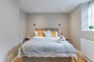 a bedroom with a large bed with yellow pillows at Cozy One Bedroom Cottage With Spacious Garden +BBQ in Brasted