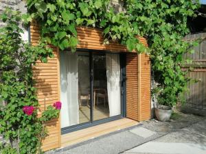 un pequeño cobertizo de madera con ventana en La Petite Boire - Chambres d'hôtes en Mûrs-Érigné