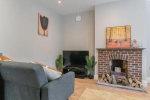 a living room with a fireplace and a tv at Cozy One Bedroom Cottage With Spacious Garden +BBQ in Brasted