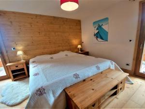 - une chambre avec un lit et un mur en bois dans l'établissement Appartement Samoëns, 5 pièces, 8 personnes - FR-1-624-13, à Samoëns