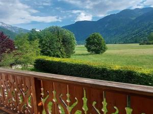 einen Holzbalkon mit Blick auf ein Feld und die Berge in der Unterkunft Appartement Samoëns, 2 pièces, 5 personnes - FR-1-624-37 in Samoëns