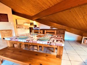 a wooden table with plates and glasses on it in a kitchen at Appartement Samoëns, 2 pièces, 5 personnes - FR-1-624-41 in Samoëns