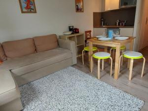 ein Wohnzimmer mit einem Sofa, einem Tisch und Stühlen in der Unterkunft Studio Samoëns, 1 pièce, 4 personnes - FR-1-624-56 in Samoëns