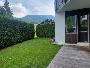 ein Haus mit einem Grashof neben einer Hecke in der Unterkunft Studio Samoëns, 1 pièce, 4 personnes - FR-1-624-56 in Samoëns