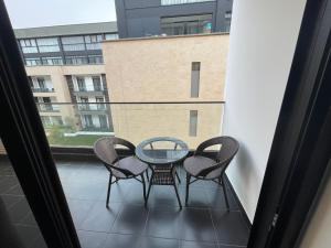 a balcony with a glass table and four chairs at Embassy Gardens Suites by Olive Gold in Cantonments