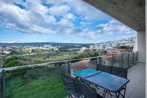 uma varanda com uma mesa e cadeiras e uma vista em Buarcos Sunset Apartment by Rent4All em Figueira da Foz