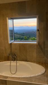 een badkamer met een bad en een raam bij Venus House in Lamas