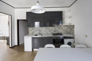 a kitchen with black cabinets and a sink and a stove at Casa Sincielli in Caorle