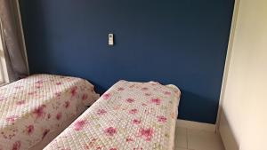 una camera da letto con due letti e una parete blu di Guarajuba Paraíso a Camaçari