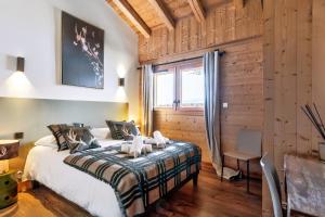 a bedroom with a large bed in a room with wooden walls at Duplex Aravis - Welkeys in Praz-sur-Arly +13 photos