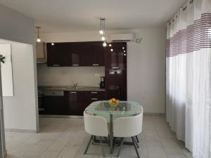 a kitchen with a glass table and two white chairs at Holiday House Rasopasno in Rasopasno +8 photos