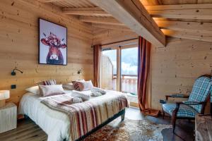 ein Schlafzimmer mit einem Bett, einem Stuhl und einem Fenster in der Unterkunft Superb and familial duplex in Praz-sur-Arly - Welkeys in Praz-sur-Arly