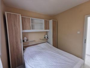 a small bedroom with a bed with wooden shelves at Holiday House Rasopasno in Rasopasno