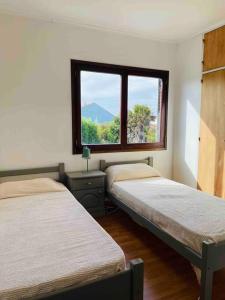 2 camas en una habitación con ventana en Super casa con vista al mar, hogar Netflix y Wifi en Mar del Plata