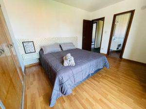 un dormitorio con una cama con un animal de peluche en Super casa con vista al mar, hogar Netflix y Wifi en Mar del Plata