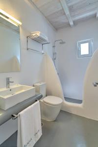 a white bathroom with a toilet and a sink at Senses Luxury Villas & Suites in Elia Beach