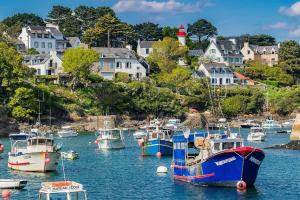 un grupo de barcos atracados en un puerto con casas en Bel appartement, proche plages pour 4 personnes, 2 chambres en Clohars-Carnoët