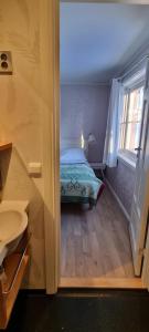 - une salle de bains avec un lit dans l'établissement Erzscheidergaarden Hotell, à Røros