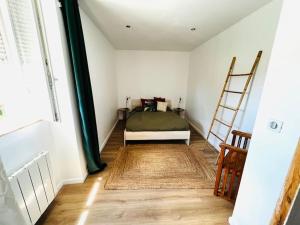 Un dormitorio con una cama y una escalera en una habitación en Bel appartement, proche plages pour 4 personnes, 2 chambres en Clohars-Carnoët
