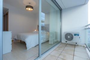 Un dormitorio con una cama y una pared de cristal. en Galante Beach Apartment II, en Figueira da Foz