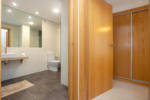 Un baño con inodoro, lavabo y espejo. en Galante Beach Apartment II, en Figueira da Foz 43 fotos más