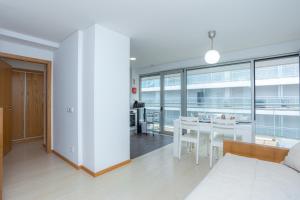 a living room with a table and a dining room at Galante Beach Apartment II in Figueira da Foz