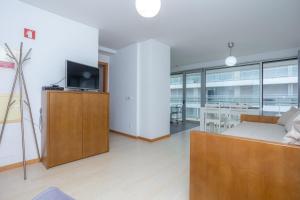 a living room with a couch and a tv at Galante Beach Apartment II in Figueira da Foz