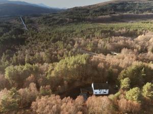 an aerial view of a house in the middle of a forest at Little Wyvis Lodge in Garve