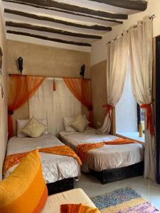 1 dormitorio con 2 camas y ventana en Riad Karmanda, en Marrakech