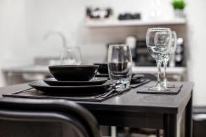 a table with two glasses and a plate and a bowl at Modern Luxury Studios London in London