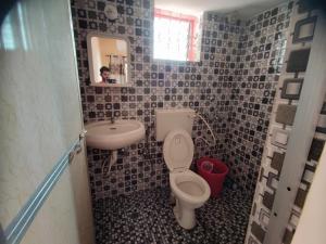 uma pequena casa de banho com WC e lavatório em Camrose Guest House em Candolim