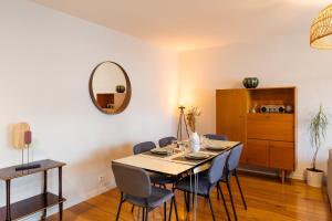- une salle à manger avec une table, des chaises et un miroir dans l'établissement Le ViLoNa - T3 moderne avec parking privé, à Rennes