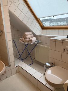a bathroom with a toilet and towels on a shelf at Pension Haus Beckmann in Borkum +53 photos