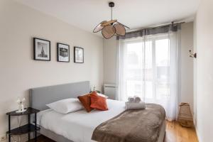 - une chambre avec un lit et une grande fenêtre dans l'établissement Le ViLoNa - T3 moderne avec parking privé, à Rennes
