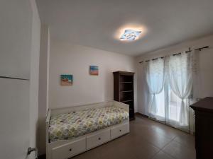 ein Schlafzimmer mit einem Bett in einem Zimmer mit einem Fenster in der Unterkunft Sophie's Oasis in Alba Adriatica