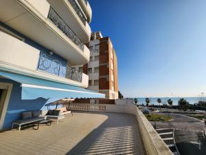 einen Balkon eines Gebäudes mit Bänken und einem Gebäude in der Unterkunft Sophie's Oasis in Alba Adriatica