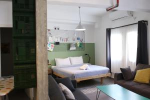 a living room with a bed and a couch at Rena's House Smart Hotel in Tel Aviv