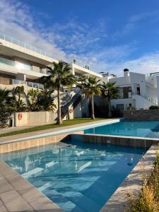 a swimming pool in front of a building at Apartamento Campana Bay con vistas a Benidorm in Finestrat