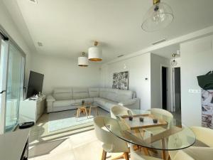 a living room with a white couch and a glass table at Apartamento Campana Bay con vistas a Benidorm in Finestrat