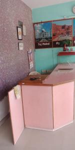 a pink counter in a room with a wall at Krishna Guest House By WB Inn in Agra
