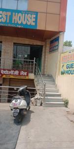 une moto garée devant une première maison dans l'établissement Krishna Guest House By WB Inn, à Agra