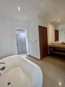 a bathroom with a tub and a sink and a mirror at Grand Baie Villa des amis sur la plage. in Grand Baie