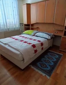 a large bed in a bedroom with a rug at Apartment inklusive Parkplatz in Velden am Wörthersee