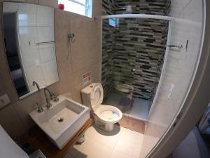 La salle de bains est pourvue de toilettes et d'un lavabo. dans l'établissement Flat Ideal Guarujá - Apto Studio Mobiliado, Ar-Condic e Cozinha Completa, à Guarujá