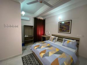 1 dormitorio con 1 cama y ventilador de techo en C7 Hazelwood Residence & Suites en Abuja