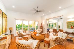 a living room with white furniture and a ceiling fan at Blue Roatan Resort in West Bay