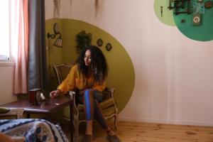 une femme assise sur une chaise dans une pièce dans l'établissement Rena's House, à Tel Aviv