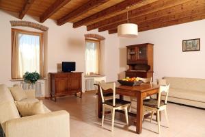 a living room with a wooden table and chairs at Residence Borgo Mondragon in Lazise