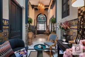 a lobby with a door and chairs and a table at Casa Catedral in Seville