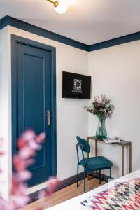 a blue door in a bedroom with a chair and a table at Casa Catedral in Seville
